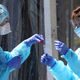 Medical personnel secure a sample at a drive-through coronavirus testing site in San Francisco.